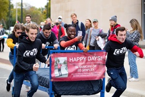 A group of students running with a bed on Riverside Ave.