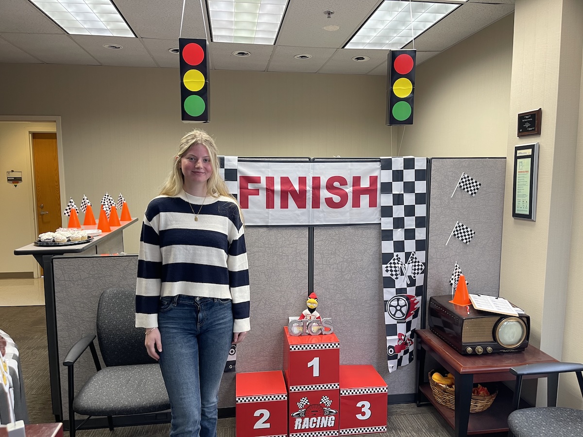 Person in front of podium racing theme in background