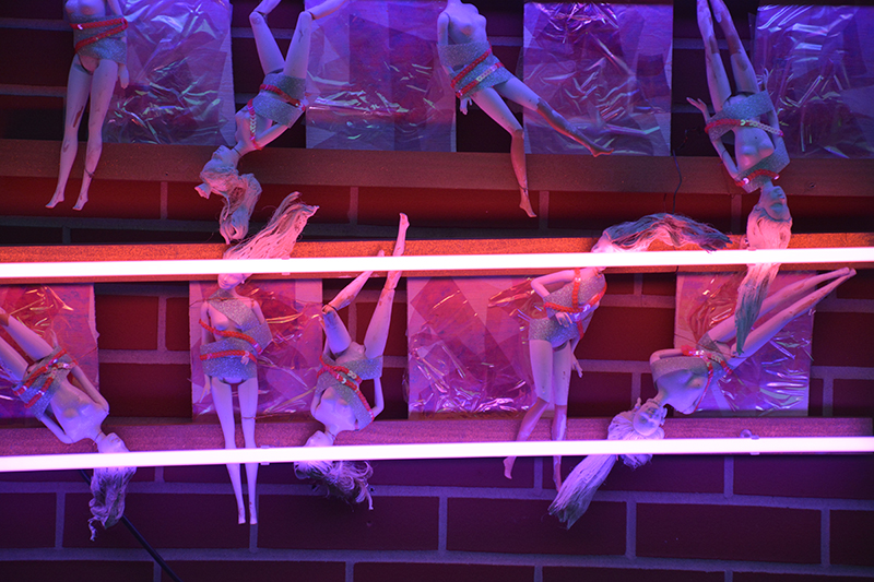 glass artwork of barbies and lights