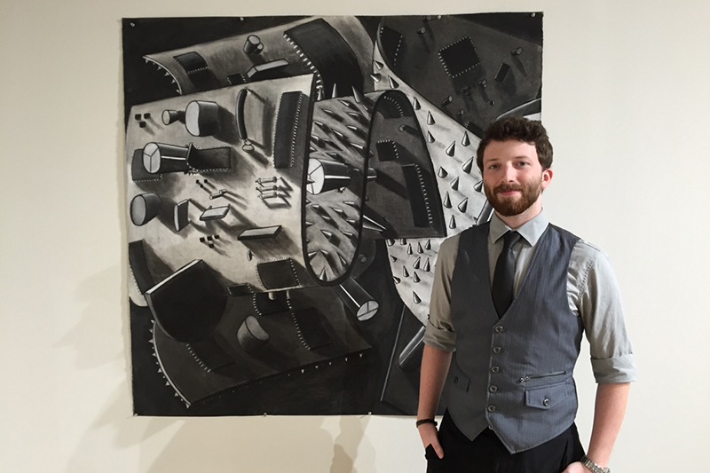 student poses in front of his drawing