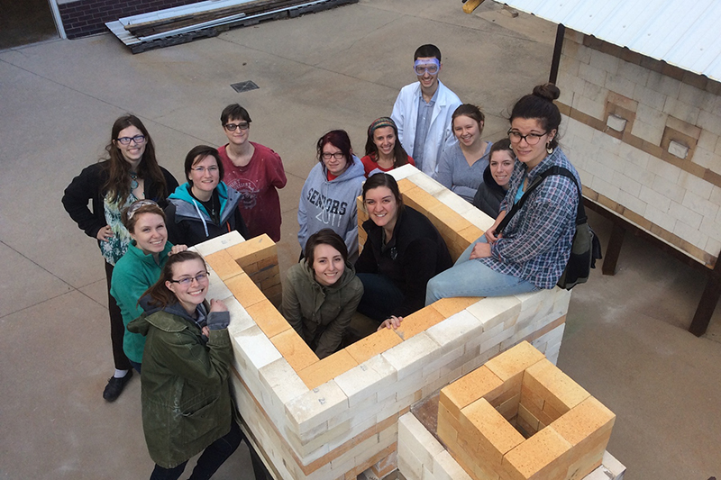 art students posing inside a kiln
