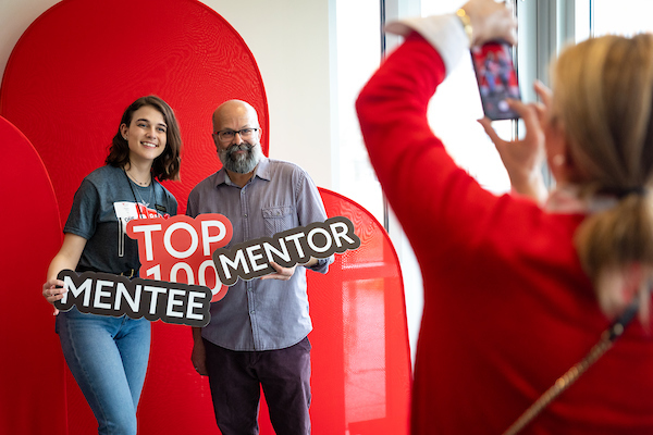 Mentor and mentee holding up signs
