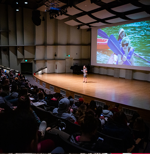 A speaker on stage at Pruis Hall