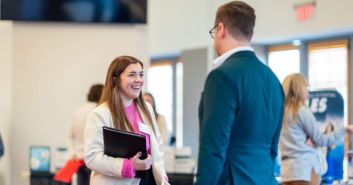 Two professionals standing discussing at the career fair