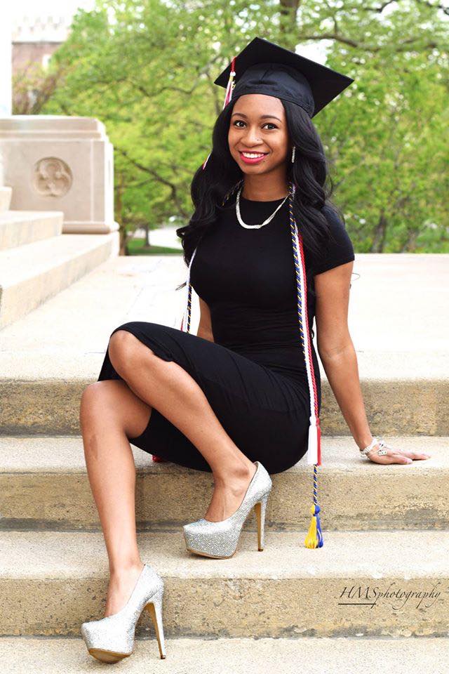 student seated, wearing commencement regalia