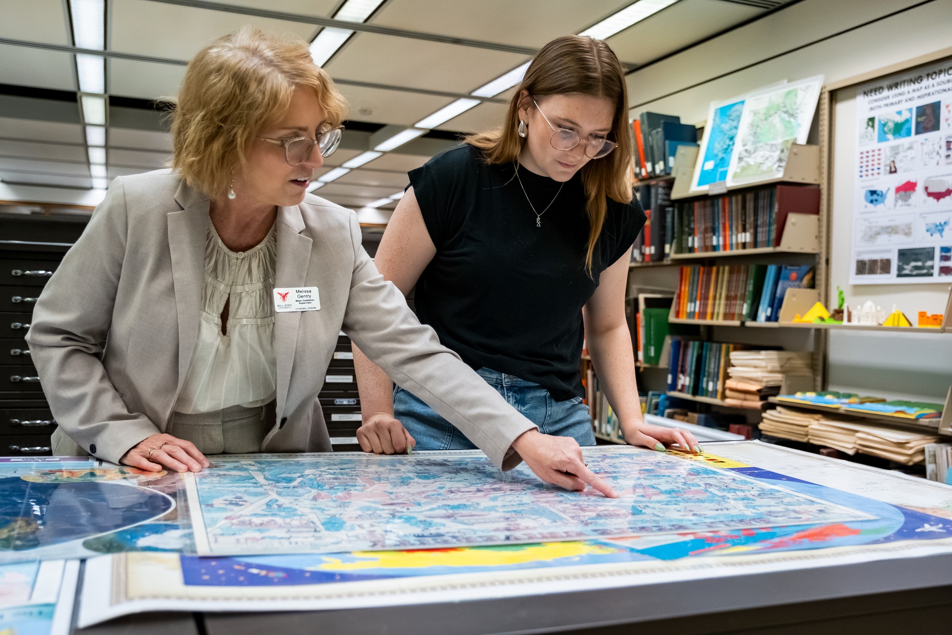 Student and Faculty looking at maps