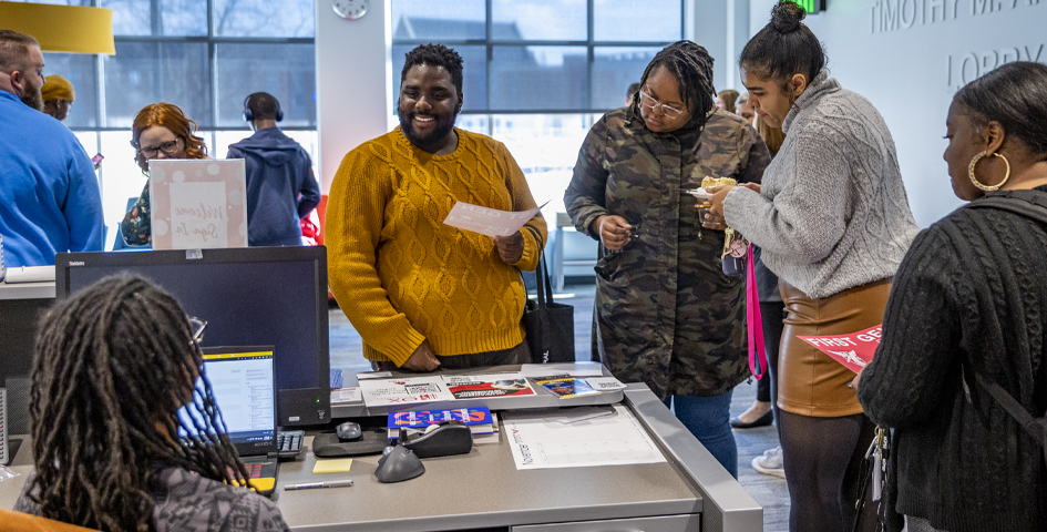 first generation student celebration students at front desk 