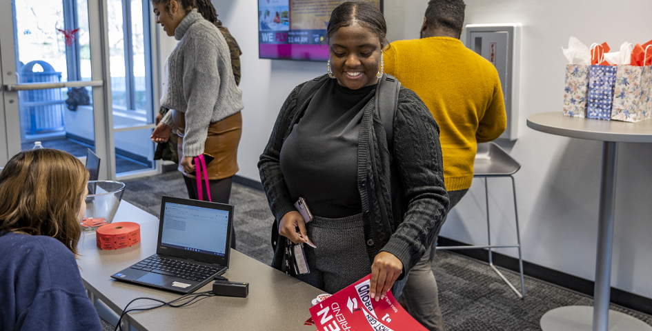 first generation student celebration student looking at first generation poster