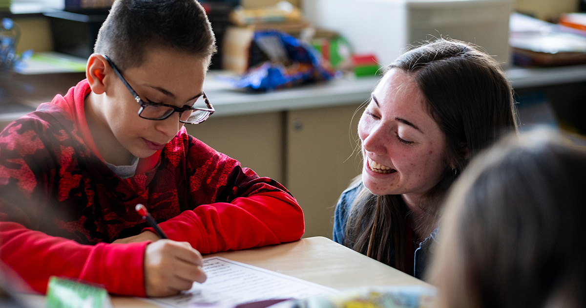 Ball State education student helping a young student with their homework