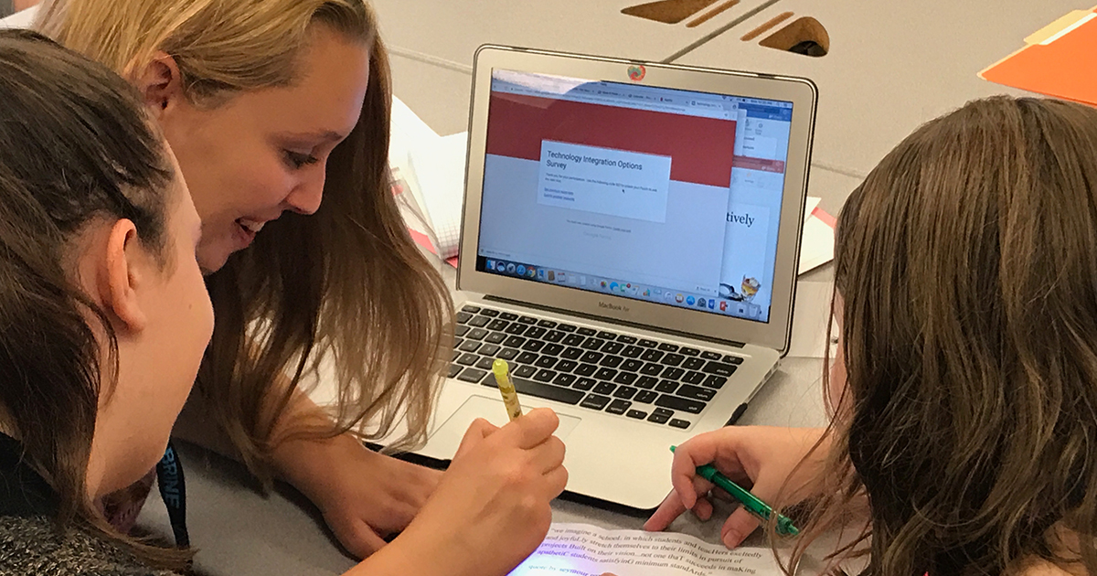 A group of students working with a laptop.