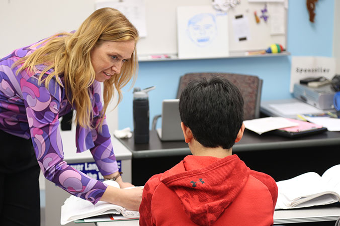 A teacher working with a young student.