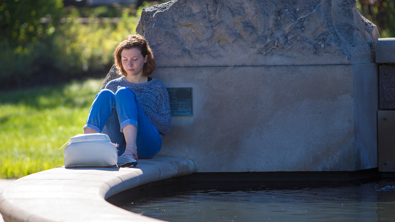 female student reading outside