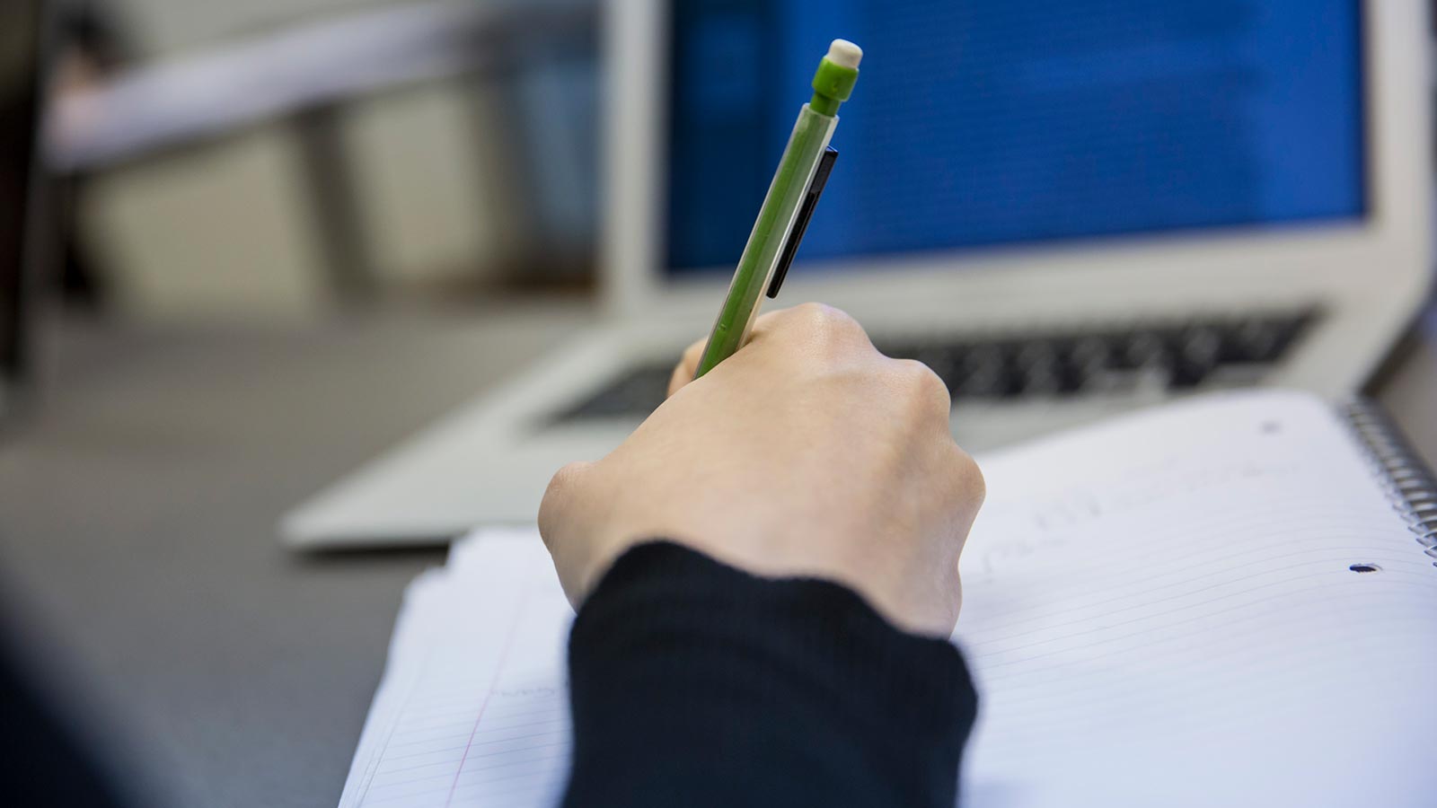 A student writing in a notebook.