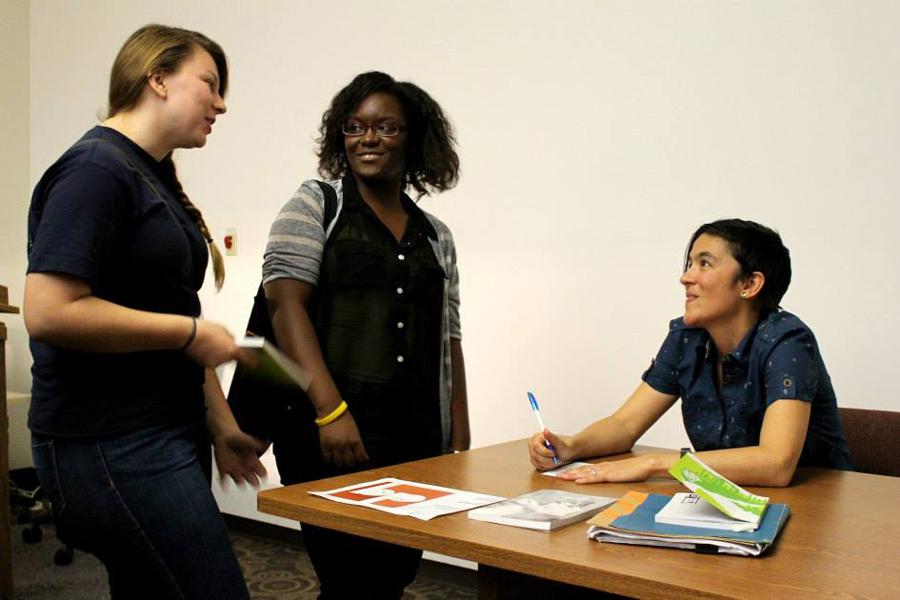 author seated, signing autographs