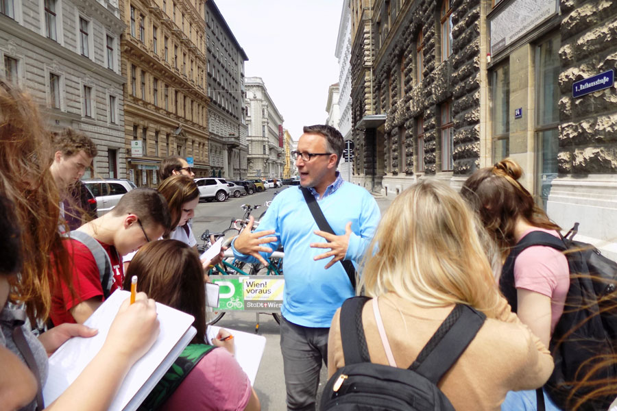 group leader speaking to students on a street in Vienna