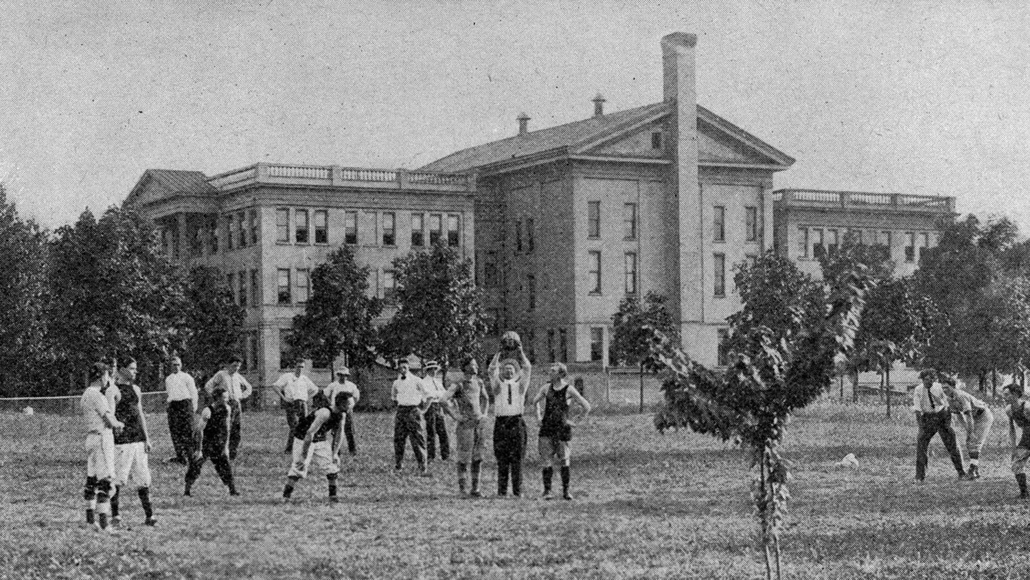 Men playing volleyball outside what is now the Administration Building.