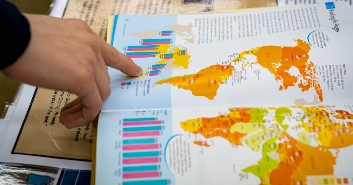 Student points to a map inside a book.