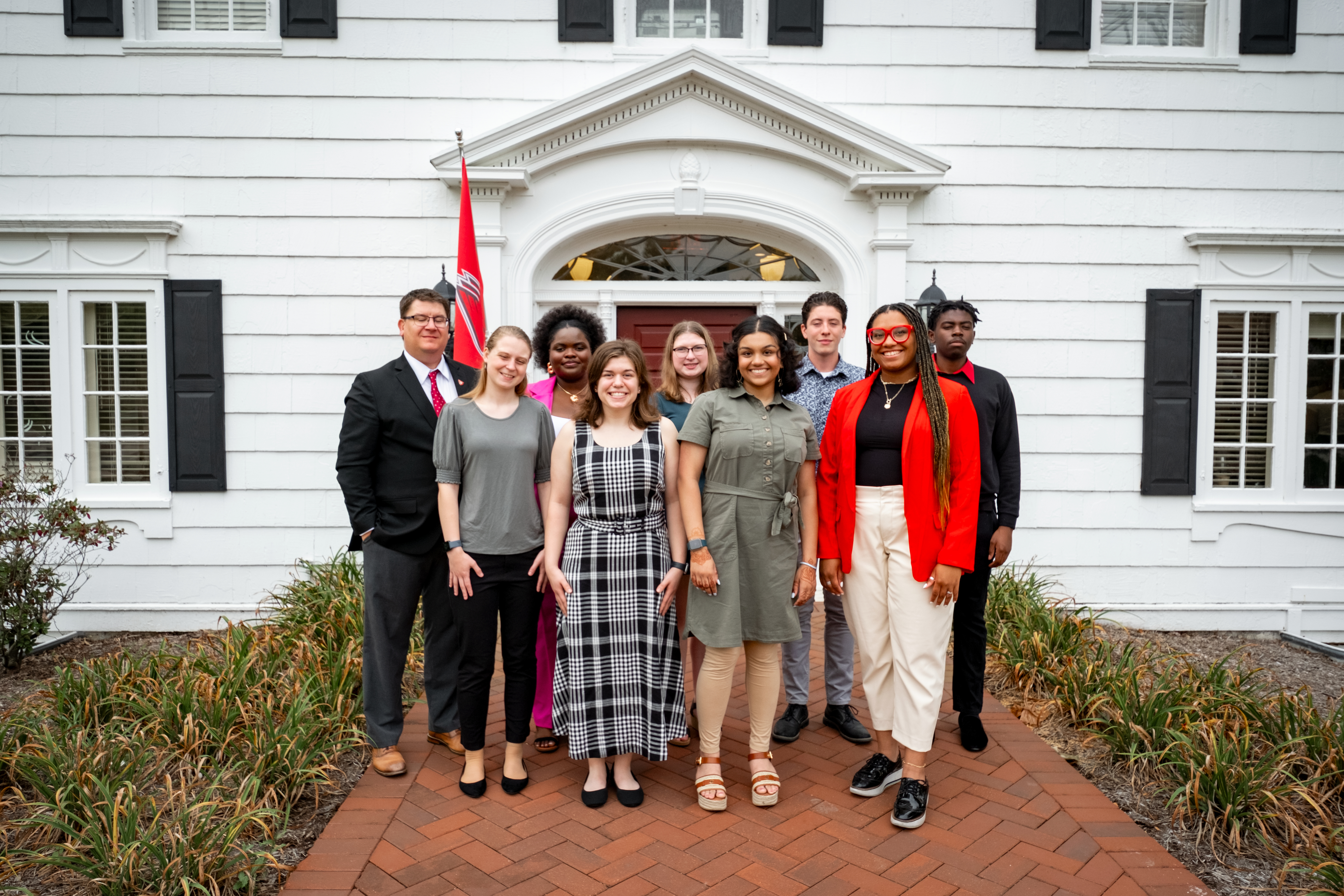2023 Whittinger Scholars posing for photos outside of the Honors College building with Dean Jim Buss