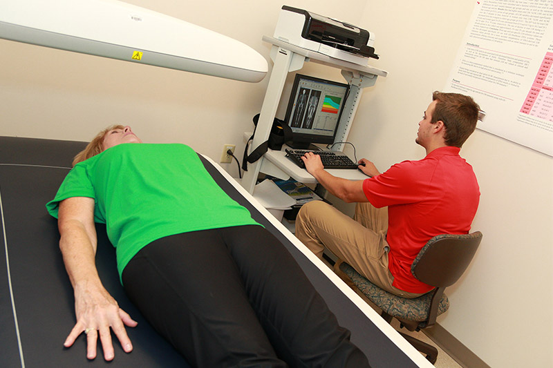 A student uses imaging equipment on a patient