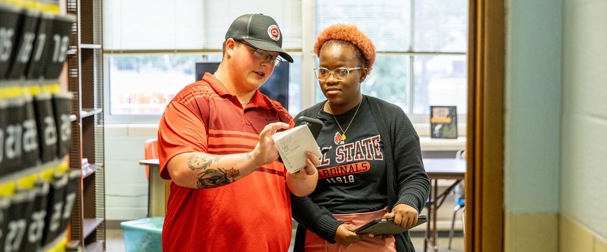 Two students converse in a hallway