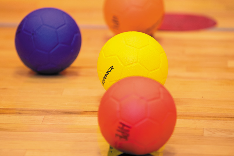 Three colorful balls on a court.