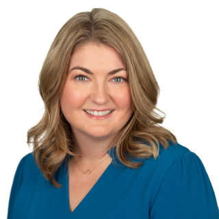 Suzanne Peperak, smiling, with medium-length blonde hair and wearing a turquoise top