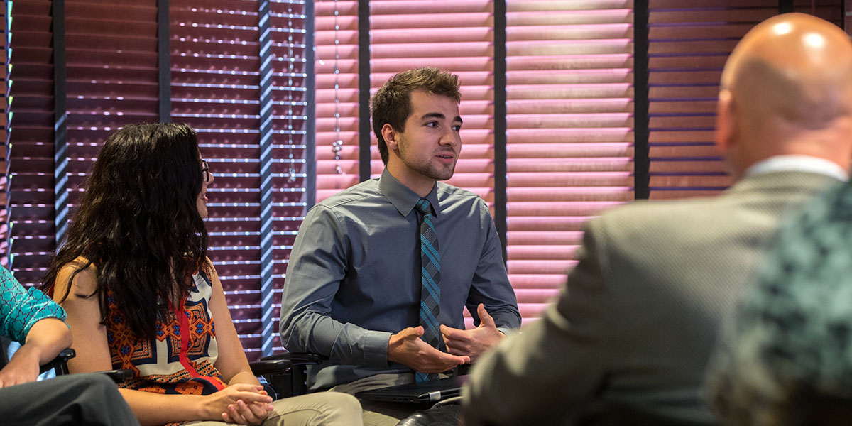 Intern speaking to businesspeople