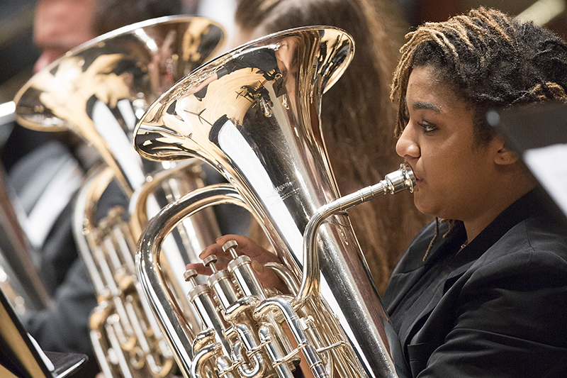 female student playing a baritone on stage