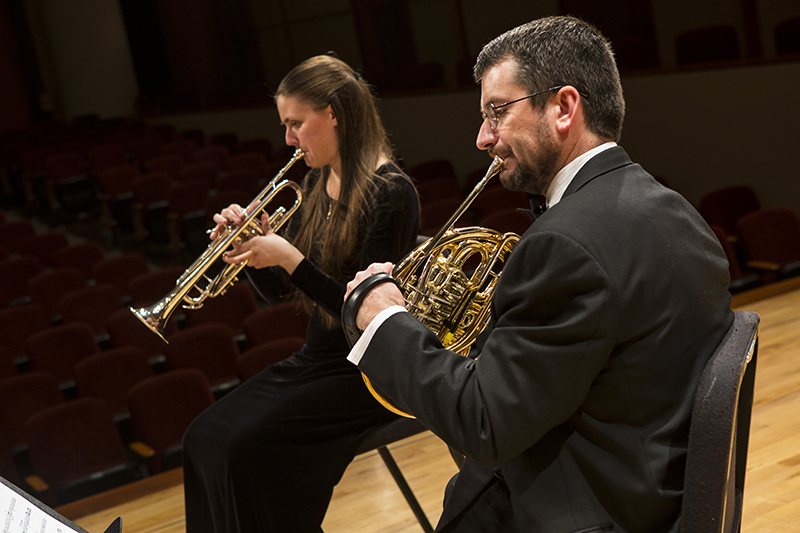 students play horns on stage