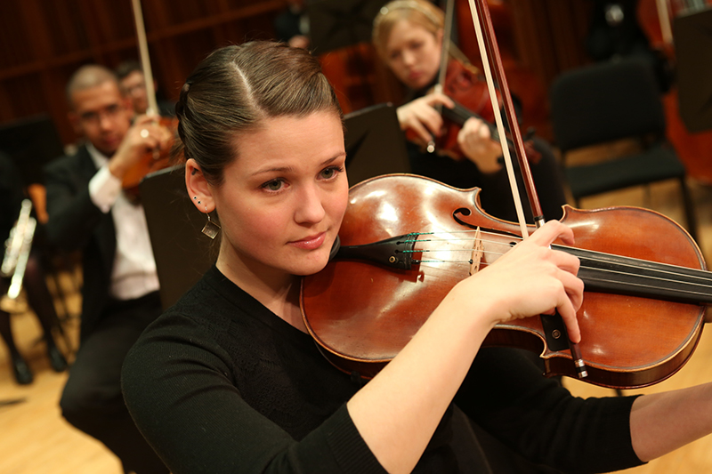 Student playing violin on stage