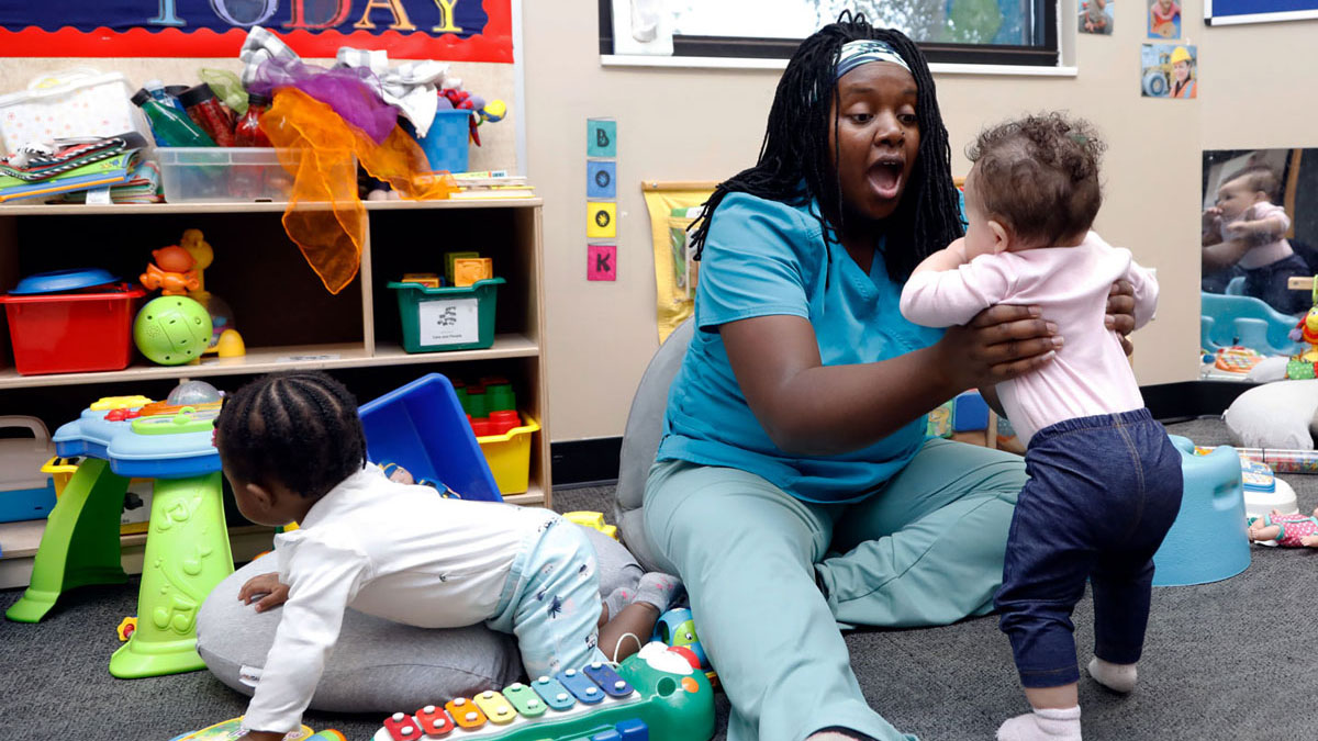 Early Childhood Education student Soanirina DeJong holding an infant in a classroom in Muncie, Indiana