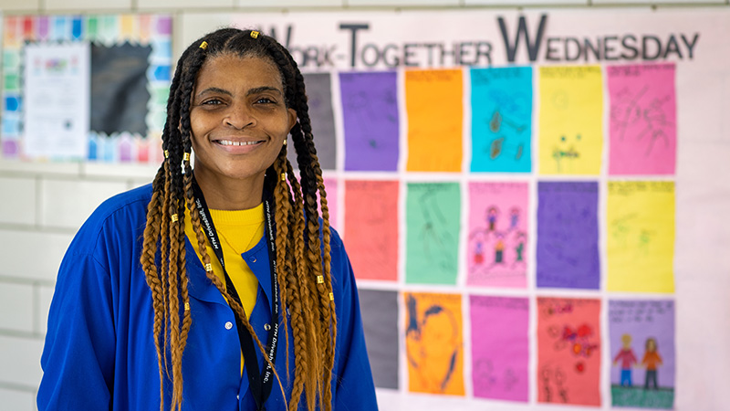 Early Childhood Bachelor's alumnus Vonda Clemons smiling in front of a school bulletin board in Muncie, Indiana