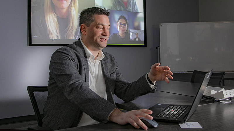 Nathan Hiscock gestures while speaking in front of a laptop
