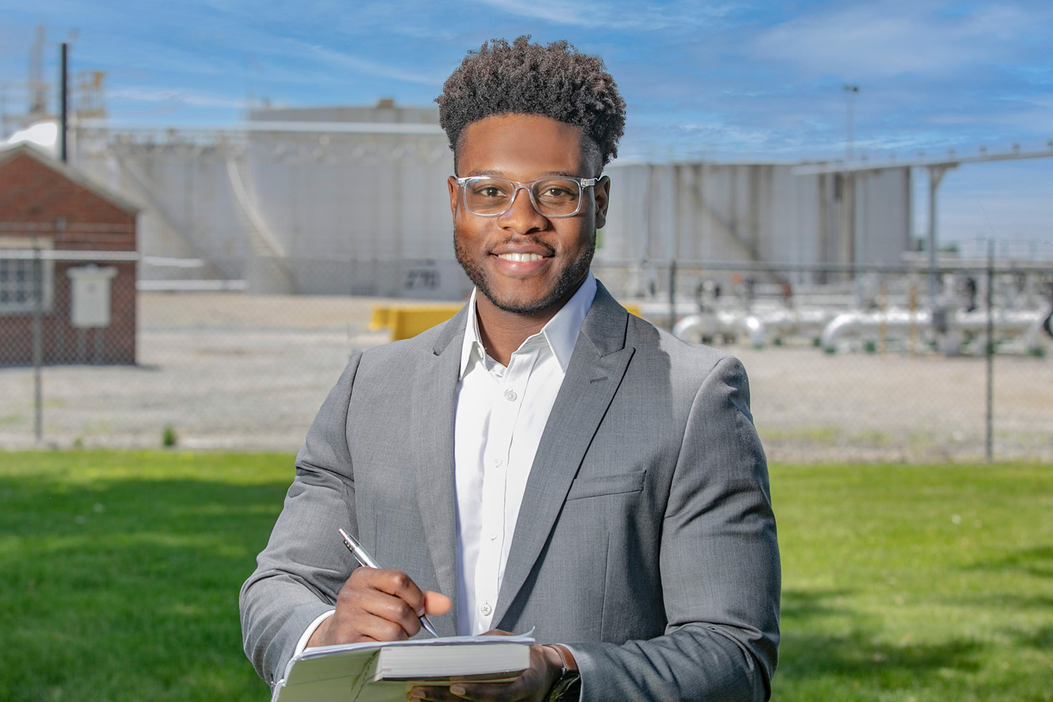 Terry Pharaon smiles while holding a notebook