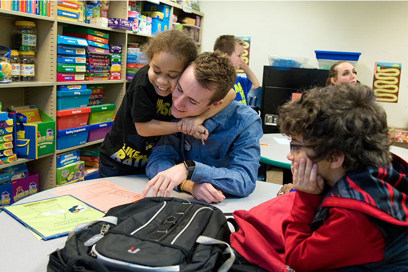 child hugging teacher