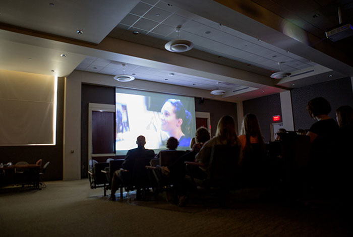 A group of students in a classroom watching a film.