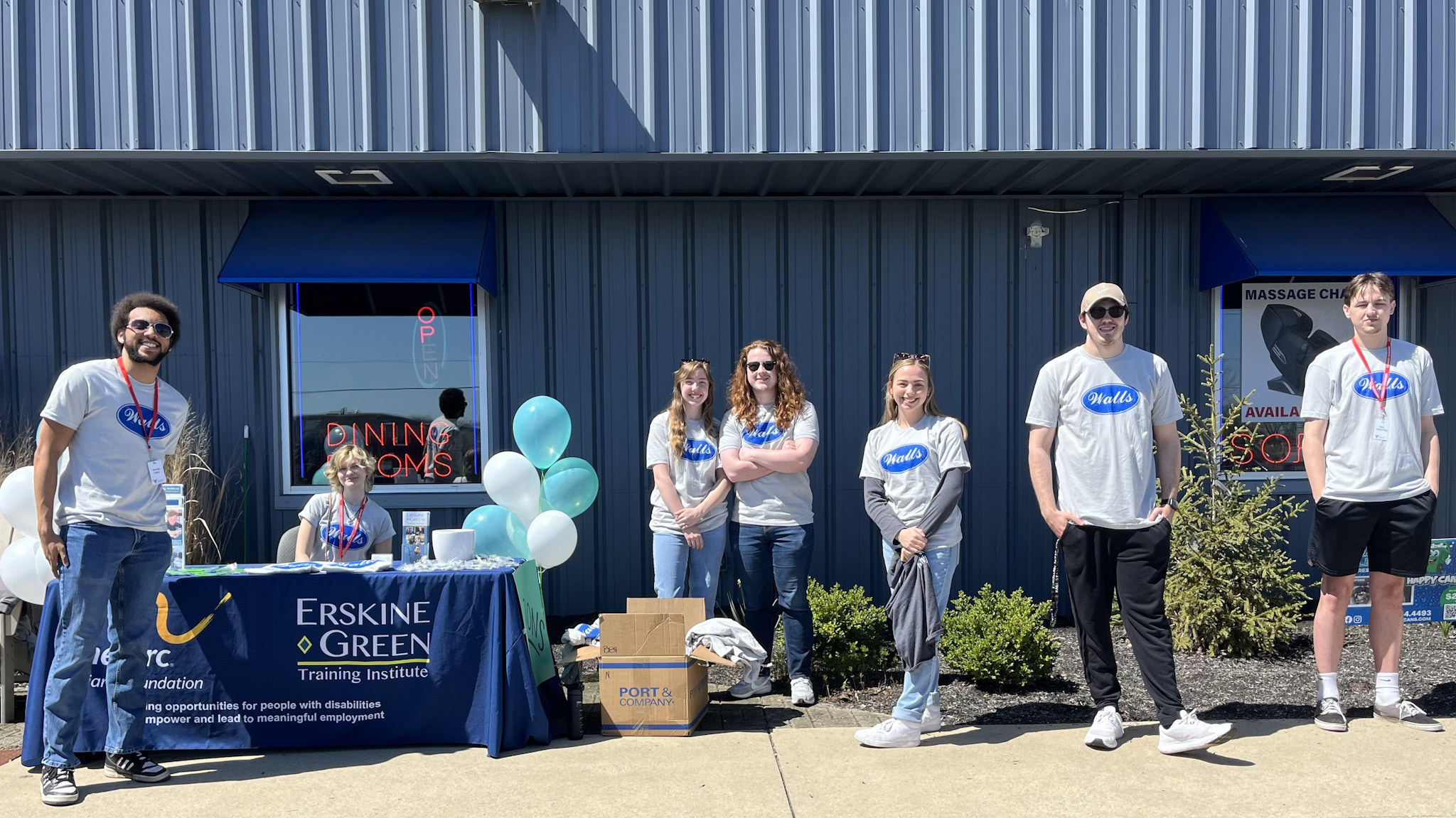 Students pose for a picture while working the car show