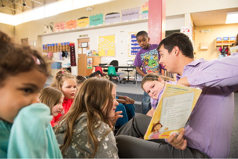 Student teacher reading to children.