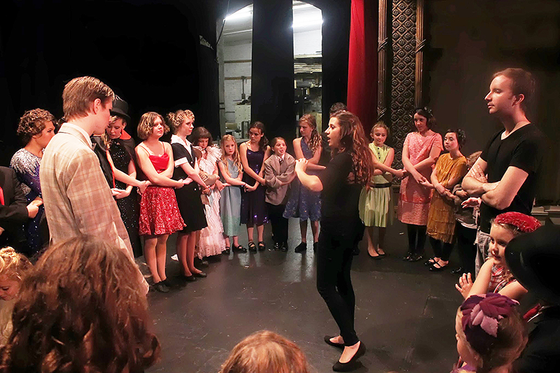 theatre education students in a circle backstage