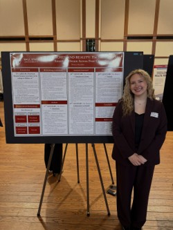 Brynne Hensley stands beside her research poster during an academic presentation event.