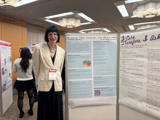 Jane Prell stands beside an academic research poster during a poster presentation event.
