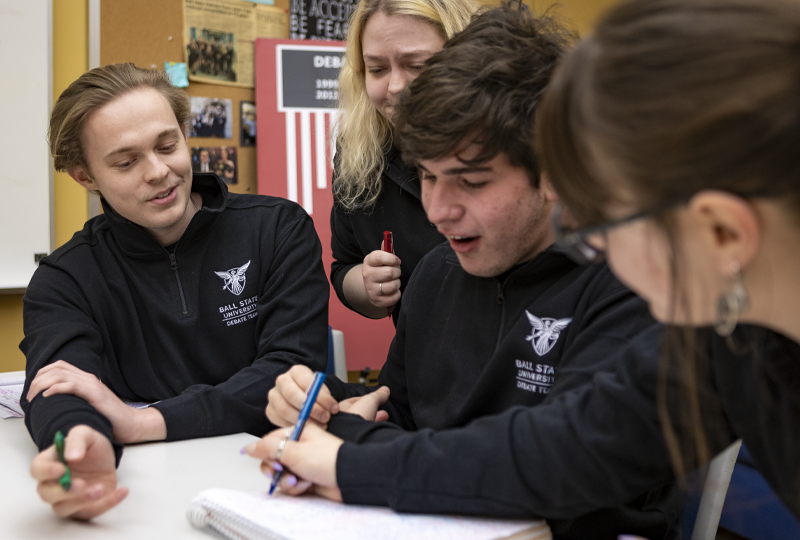 Students with professors talking about an assignment