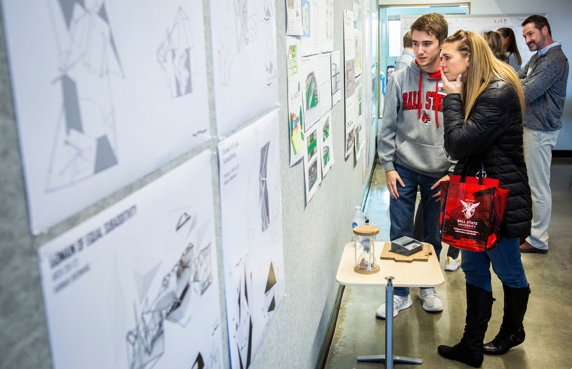 Attendees of Counselor Connection Day touring the inside of the College of Architecture and Planning building and looking at blueprints hung up.