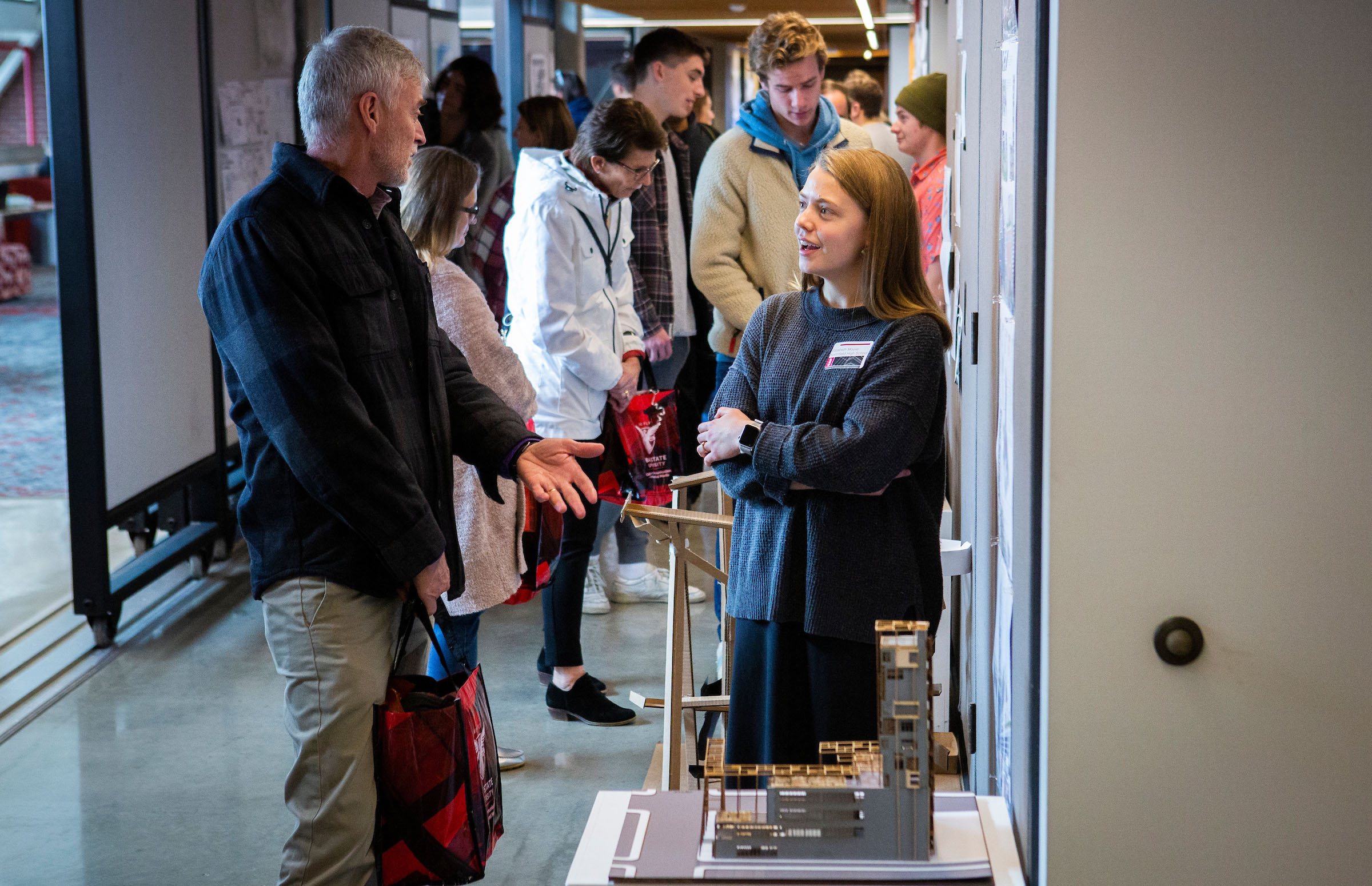 Attendees of Counselor Connection Day socializing and looking at various student projects in the College of Architecture and Planning Building