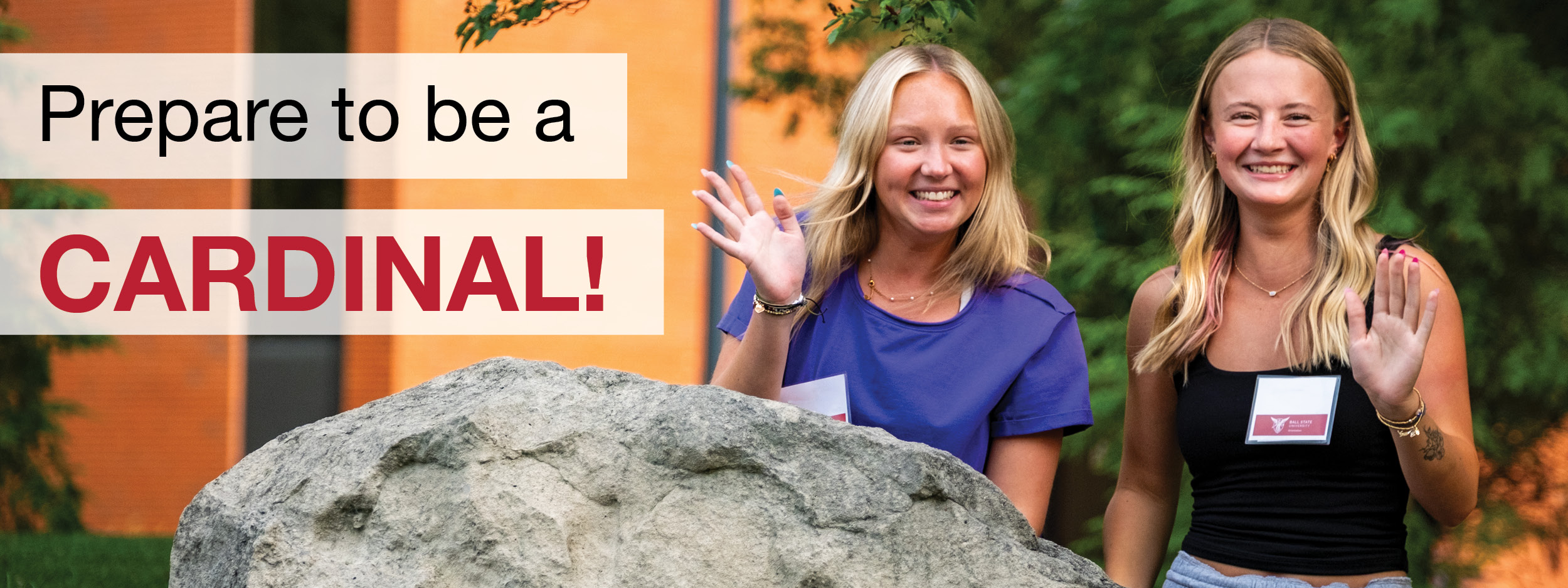 Prepare to be a cardinal text in the left corner of the image with two female students in the right corner of the picture waiving