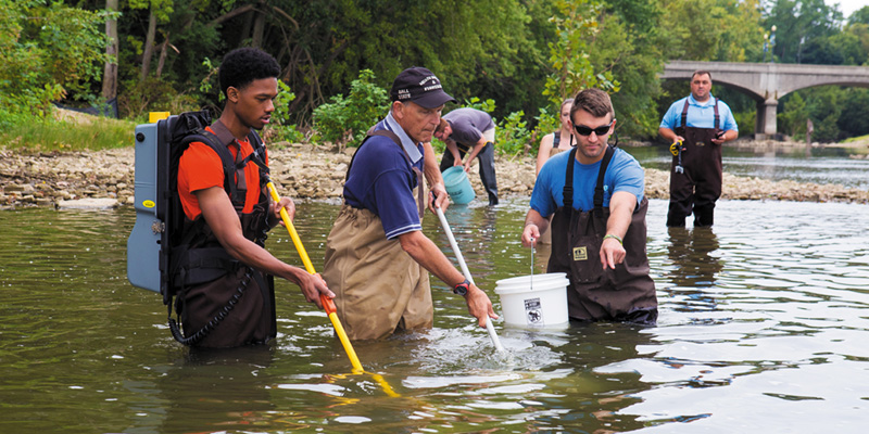 Professor and students working in the river