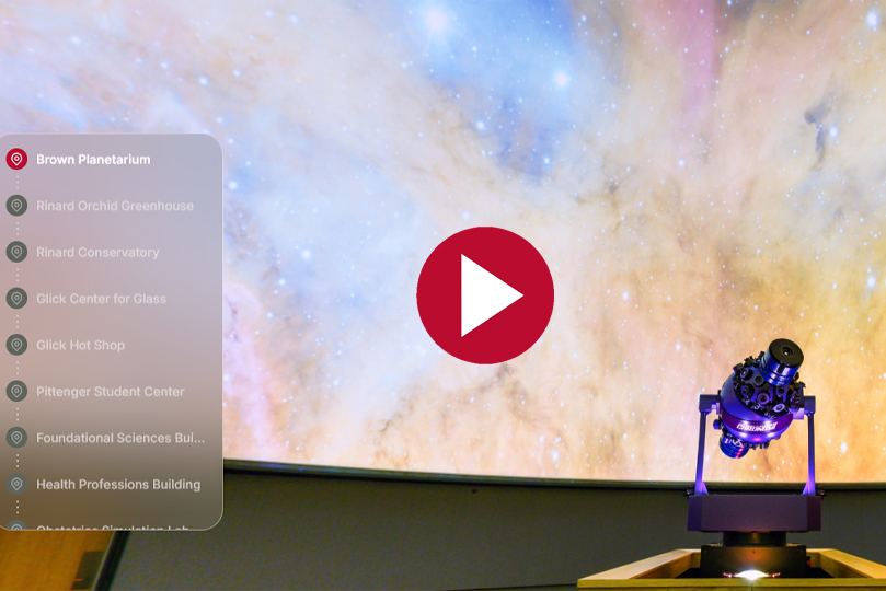 Tour screenshot of the planetarium with a menu on the left, a play button in the center and the screen of the planetarium and telescope in the background
