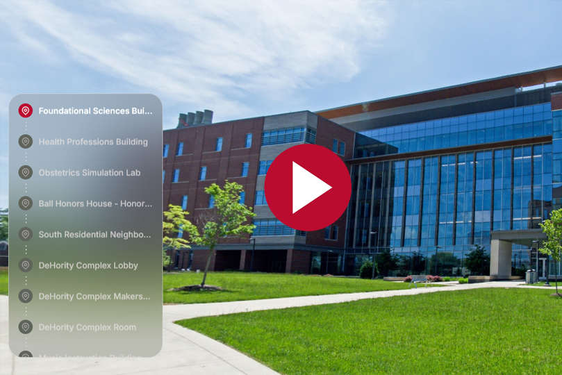 tour screenshot of the foundational sciences building, a menu on the left and a play button in the center with the building in the background