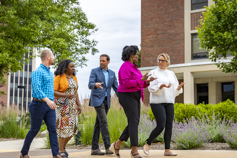 Employees walking on campus and talking