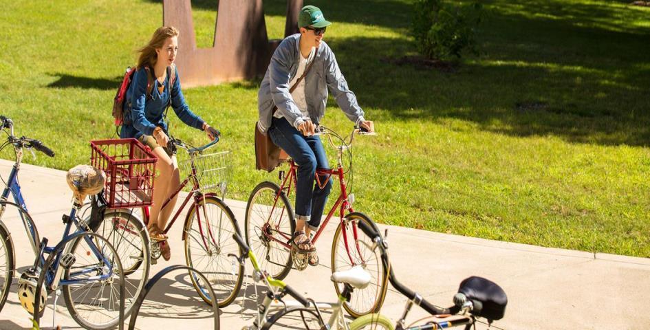 students riding bikes on campus